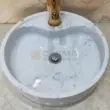 Round white marble vessel sink with polished finish and elegant design. Ideal for modern bathrooms.