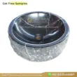 Black marble sink with polished surface and unique veining, perfect for luxury bathroom designs.