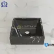 Black marble sink with white veining, perfect for a modern bathroom design.